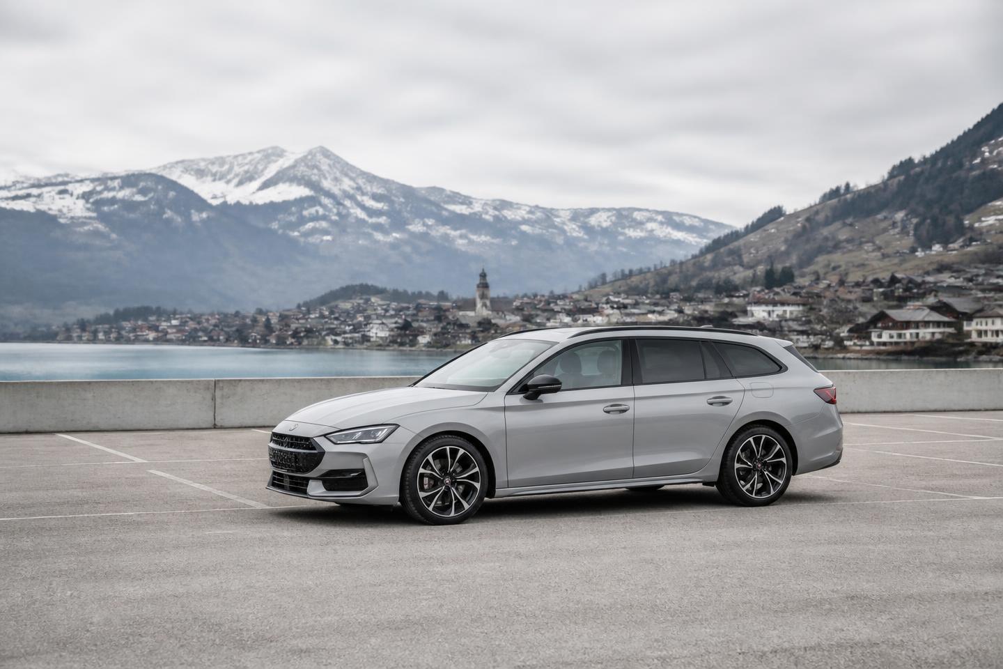 Silver estate car parked in front of a Swiss lake and mountains